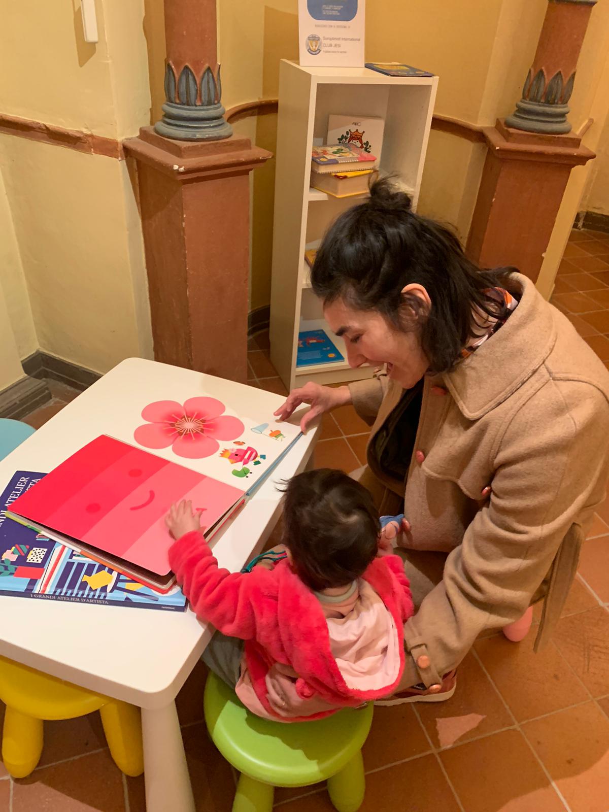 Un bambino con la mamma sfogliano un libro di disegni