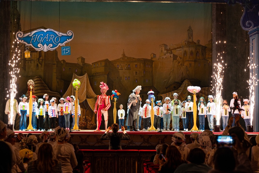 Foto di rappresentazione teatrale con personaggi in costumi colorati e scenografici