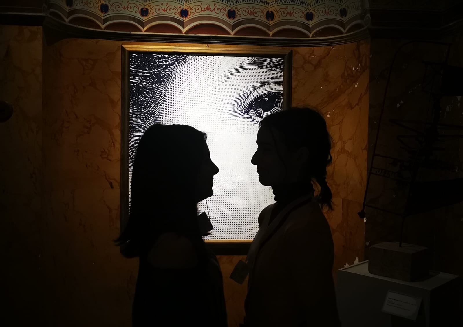 Silhouette di due ragazze di fronte al quadro 