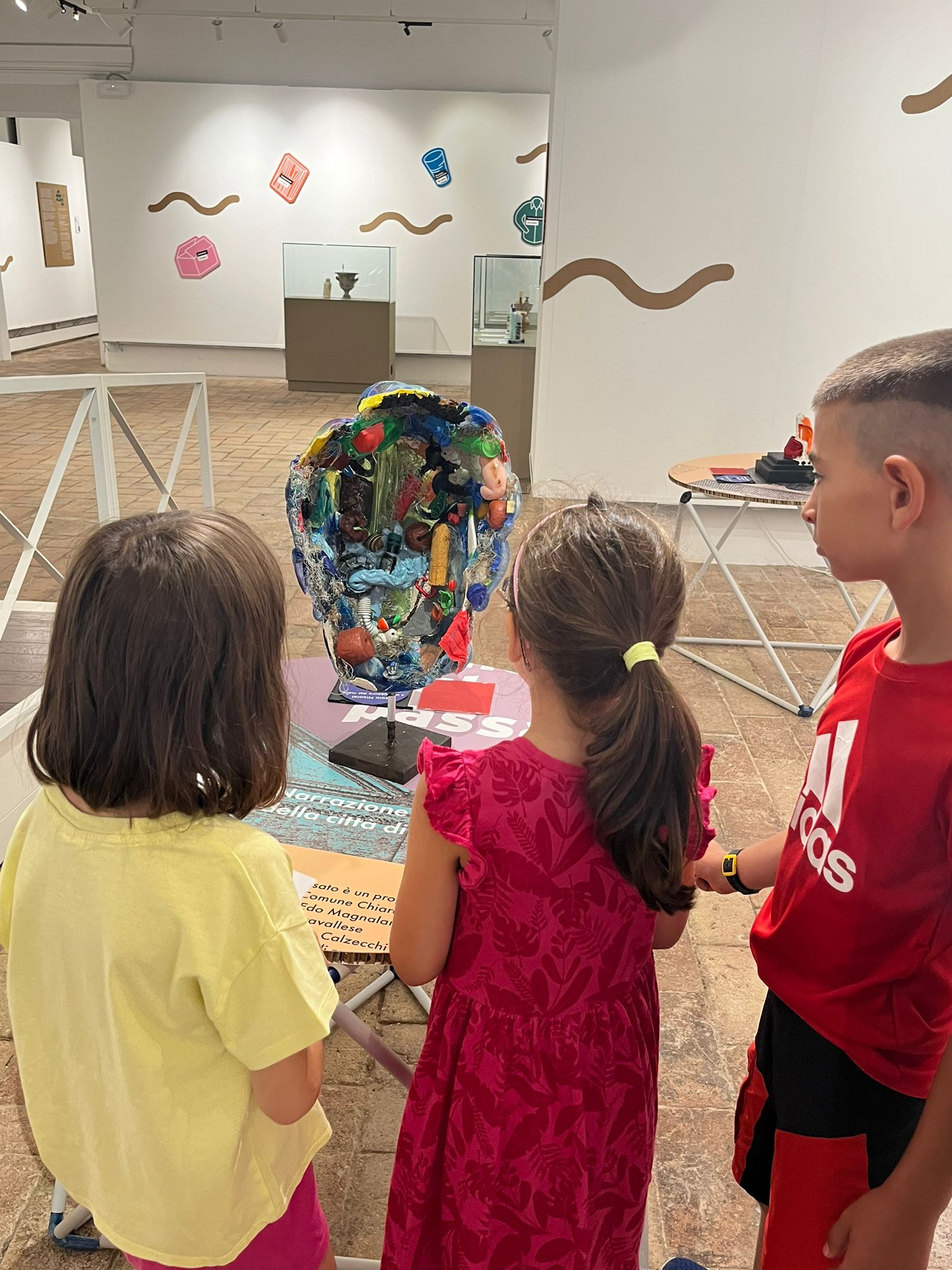 Bambini guardano un'opera di arte contemporanea in mostra 